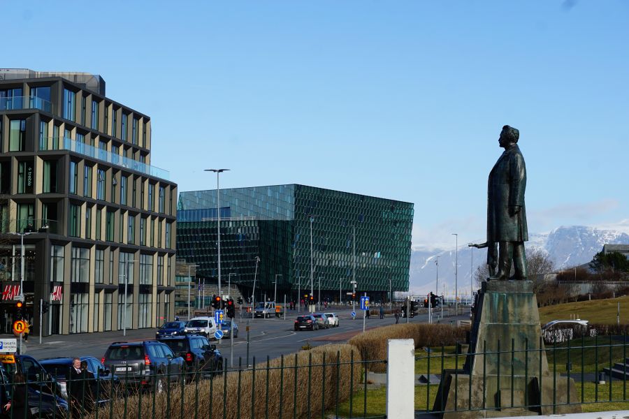 Stadtansicht von Reykjavik mit modernen Gebäuden und einer Statue im Vordergrund.