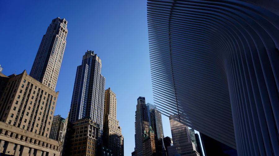 Blick auf Wolkenkratzer in New York City mit klarem, blauem Himmel im Hintergrund.