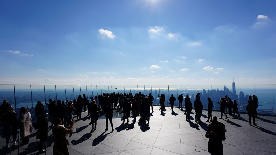 Blick von der Aussichtsplattform The Edge in New York mit vielen Besuchern, die die Skyline von Manhattan bewundern, unter blauem Himmel mit einigen Wolken.