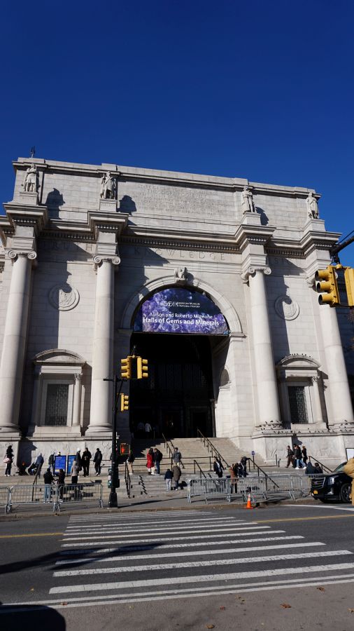 Blick auf den Eingangsbereich des American Museum of Natural History in New York City mit blauer Himmel im Hintergrund.