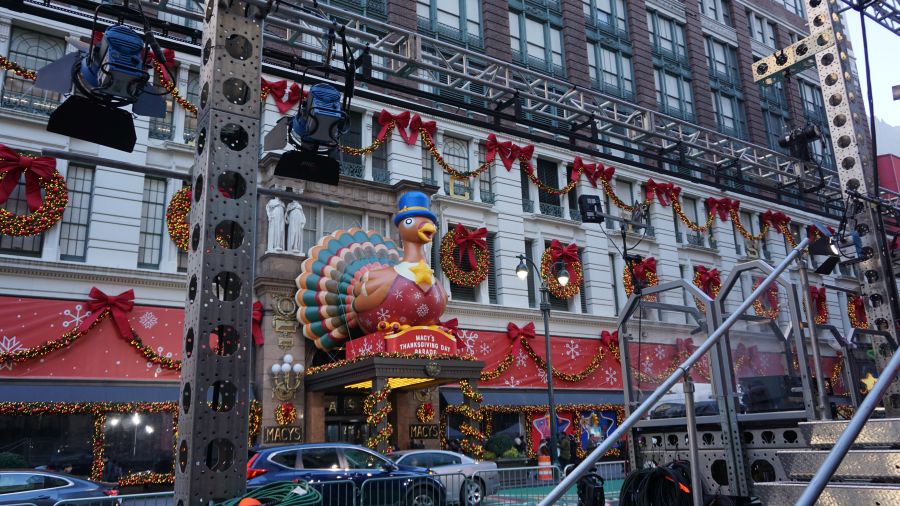 Ein festlich dekoriertes Macy's mit einem großen Truthahn als Paradefigur und weihnachtlicher Dekoration.