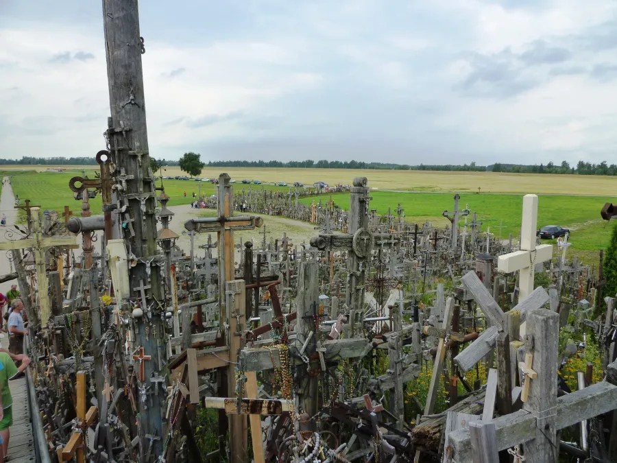 Panorama des Berges der Kreuze mit einer Vielzahl an Holzkreuzen und der umliegenden Landschaft.