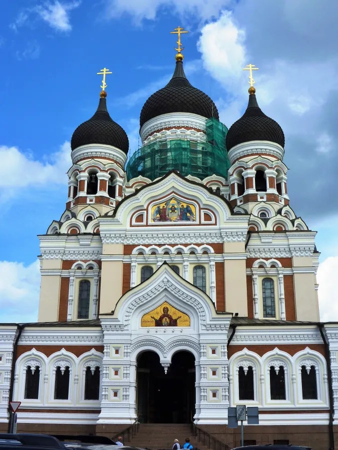 Die Alexander-Newski-Kathedrale in Tallinn mit ihren charakteristischen Zwiebelkuppeln und Kreuzspitzen vor einem blauen Himmel.