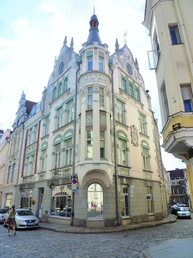 A corner view of an ornate, early 20th-century building with decorative elements and large windows in Tallinn, Estonia.