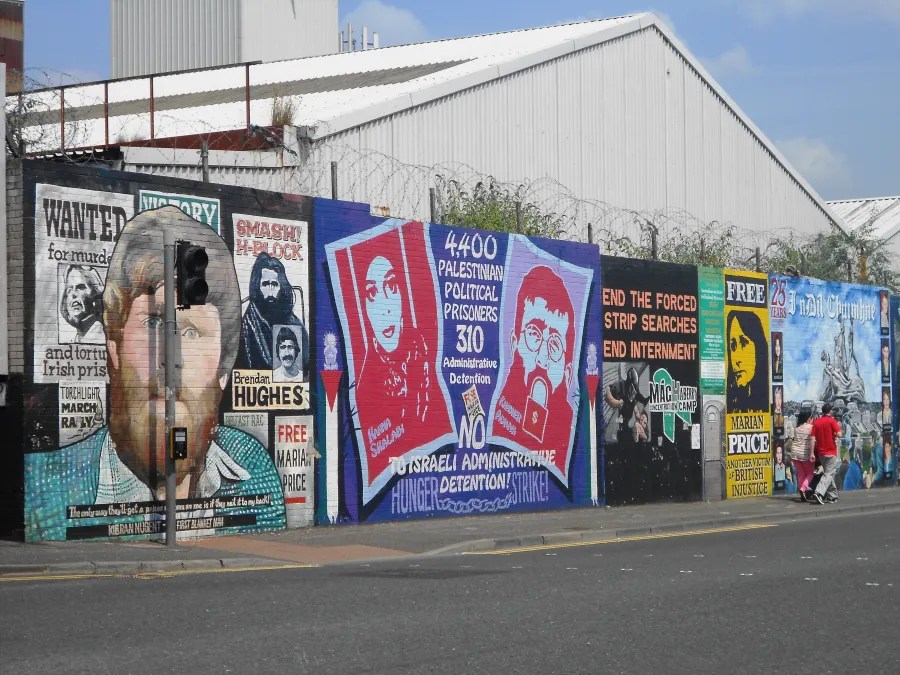 Wandgemälde in Belfast, Nordirland, die politische Themen und Proteste darstellen, mit historischen Figuren und Botschaften zu politischen Gefangenen.