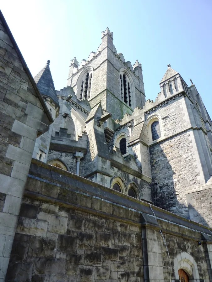 Blick auf eine historische Kirche mit markanten Türmen und steiniger Fassade, aufgenommen aus einem niedrigen Winkel.