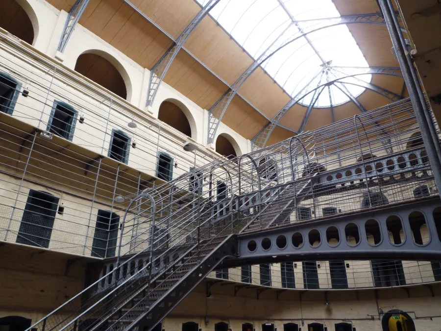 Blick ins Innere eines historischen Gefängnisses mit gewölbten Decken, Treppen und Fenstern.