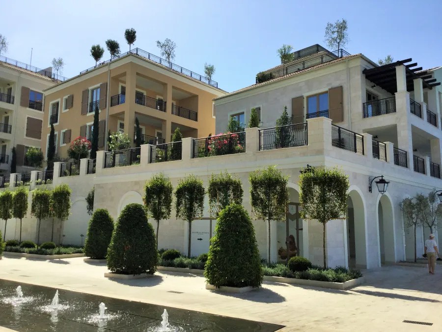 Moderne Wohngebäude mit Terrassen und Bepflanzung in Tivat, Montenegro, umgeben von gepflegten Gärten und Springbrunnen.