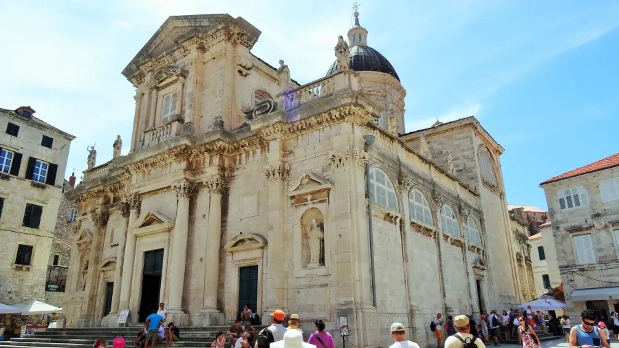 Eine Fassade der Kirche St. Blasius in Dubrovnik, Kroatien, mit einer Gruppe von Touristen vor dem Gebäude.