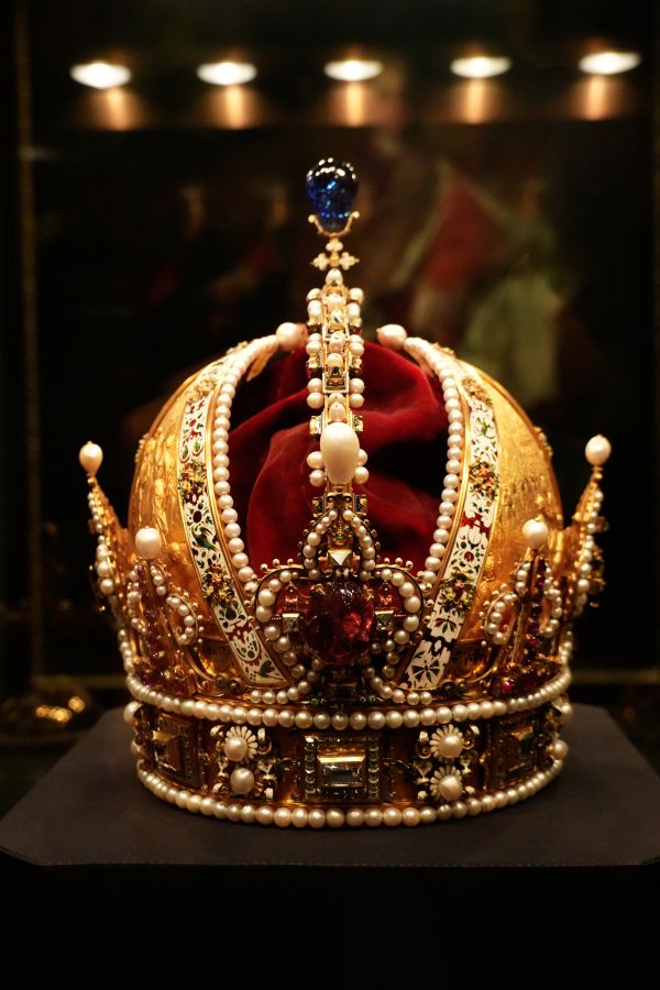 Kaiserkrone mit roten und weißen Verzierungen, ausgestellt unter Glas.