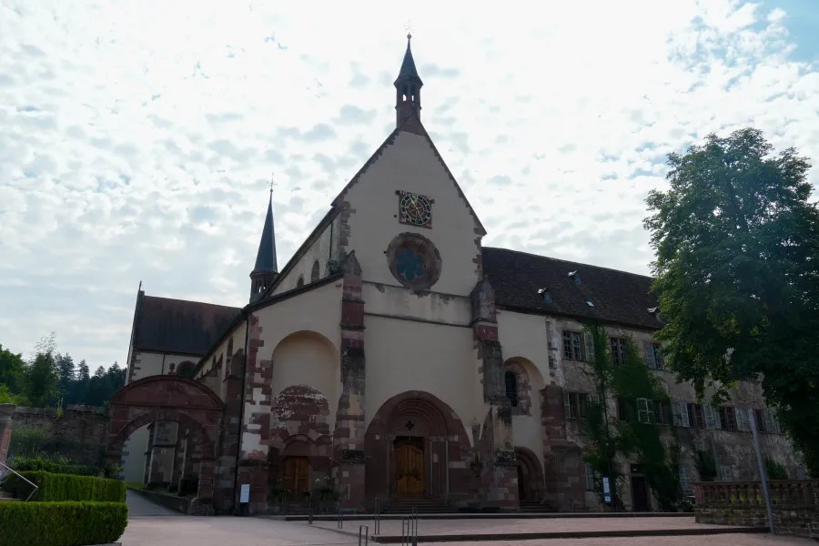 Exterior view of Kloster Bronnbach with a decorative facade and cloudy sky.
