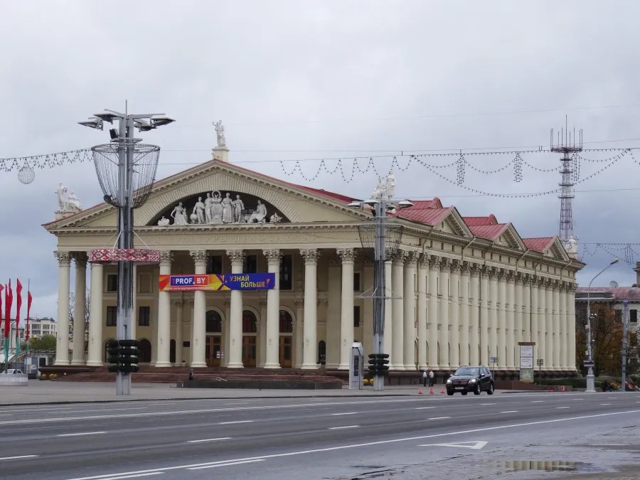 Gebäude des Nationalen Akademischen Kostenko-Theaters in Minsk mit Säulenfassade und Dekorationen, umgeben von Straßen und Verkehr.