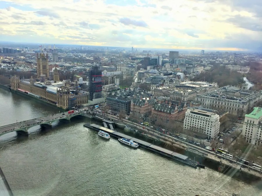 Blick über die Themse in London mit dem Palace of Westminster und der Big Ben im Hintergrund sowie verschiedenen Gebäuden und Brücken sichtbar.
