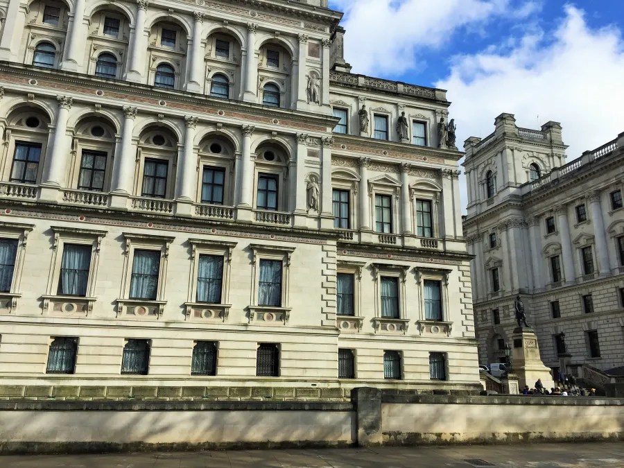 Fassade eines historischen Gebäudes in London, mit eleganter Architektur und dekorativen Elementen unter einem blauen Himmel.