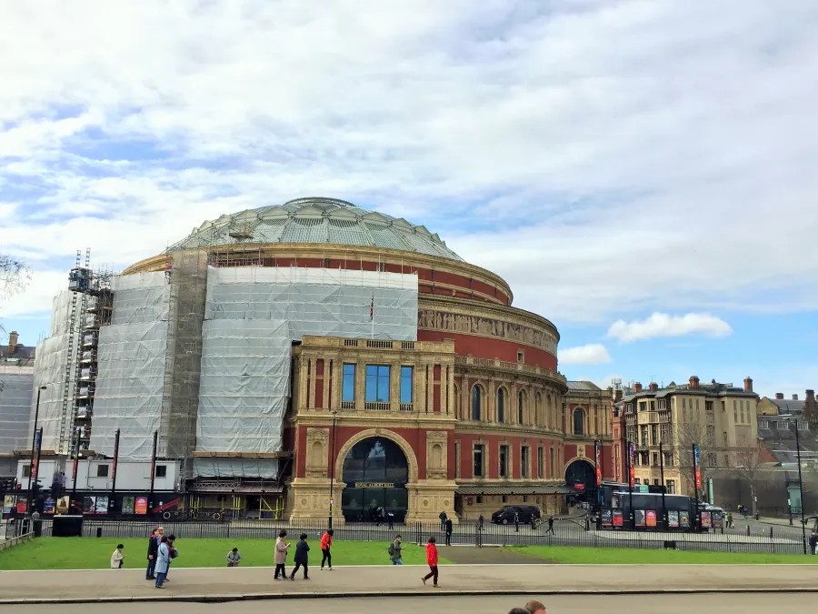 Die Royal Albert Hall in London während Renovierungsarbeiten, umgeben von Scaffolding und blauen Himmel.