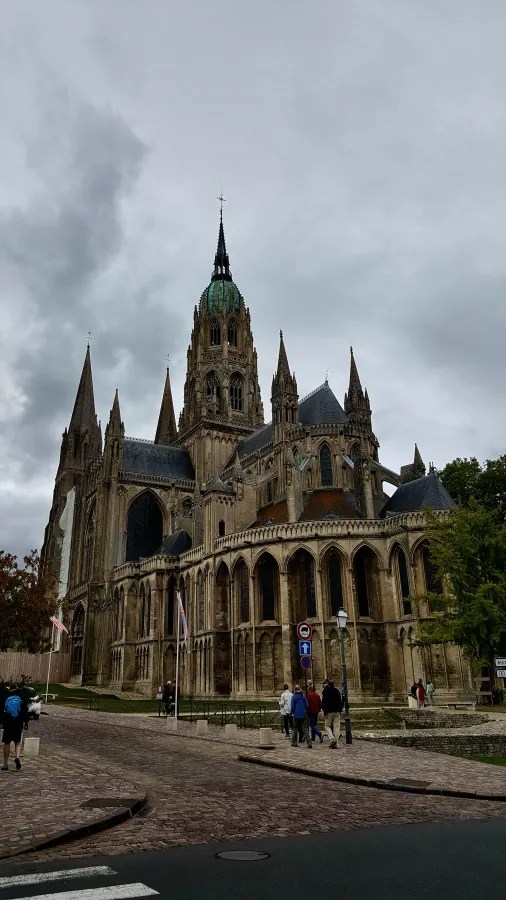 Eine beeindruckende gotische Kathedrale in einer Stadt, umgeben von grauem Himmel und zeigen Besuchern auf der Straße.