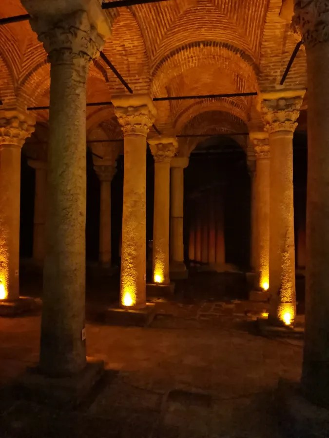 Einblick in die Basilica Cistern in Istanbul mit beleuchteten Säulen und einem dunklen, geheimnisvollen Raum.