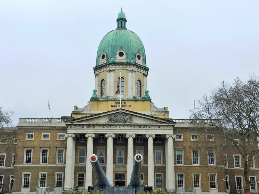 Außenansicht des Imperial War Museum in London mit markantem Kuppeldach und großen Kanonen im Vordergrund.