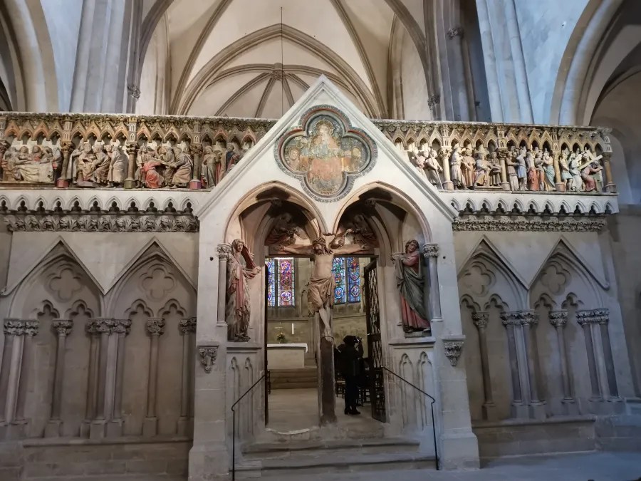 Inneres des Naumburger Doms mit einem kunstvoll gestalteten Altar und bunter Glasmalerei.