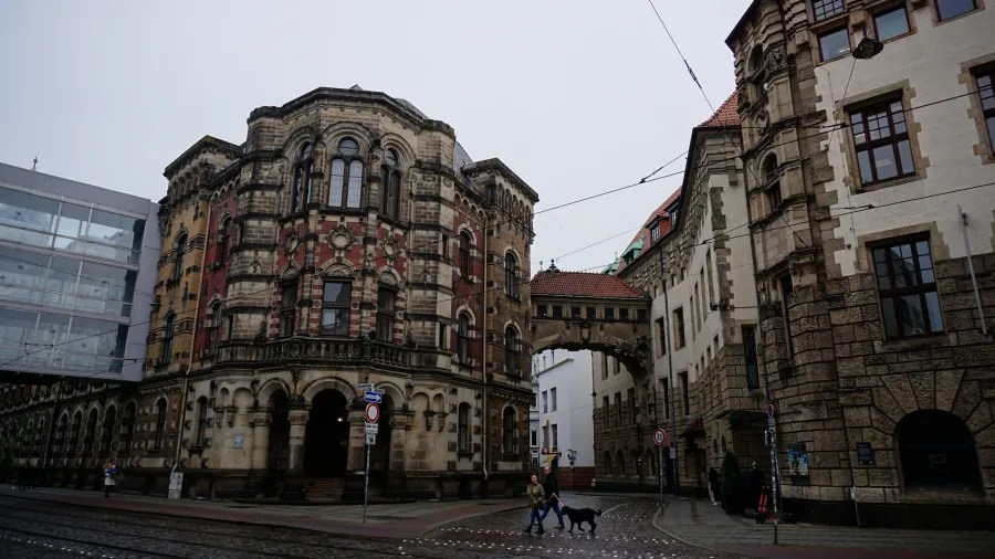 Eine Straße in Bremen mit historischem, verziertem Gebäuden und einem Mann, der mit einem Hund spazieren geht.