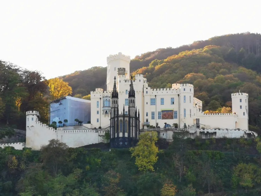 Schloss Stolzenfels am Rhein mit bunten Herbstbäumen im Hintergrund.