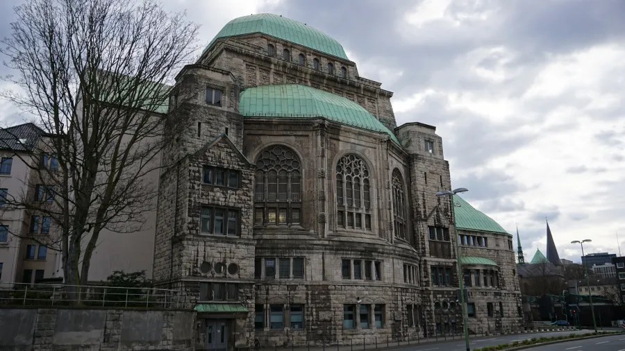 Ansicht der Alten Synagoge in Essen mit markantem Gründach und historischer Architektur, umgeben von urbaner Umgebung und grauem Himmel.