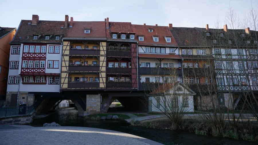 Historic buildings along a canal, featuring traditional architecture with timber framing and colorful facades.