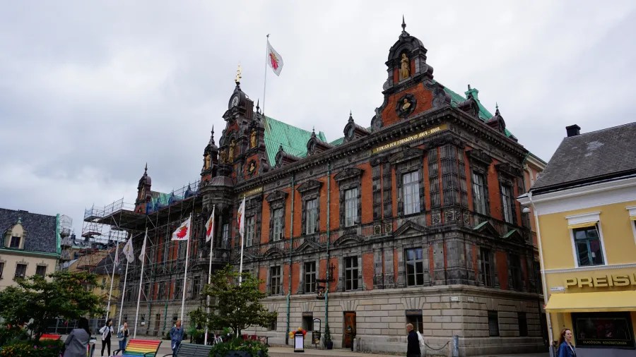 Historisches Gebäude in Malmö mit markanter Architektur, umgeben von Fahnen und Baugerüsten.