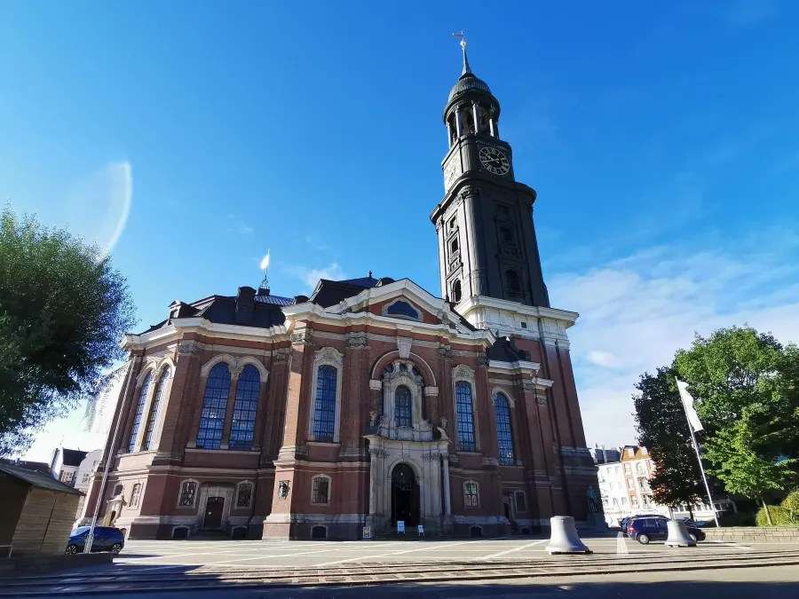 Die Hauptkirche St. Michaelis in Hamburg, auch als Michel bekannt, im strahlenden Sonnenschein mit einem blauen Himmel im Hintergrund.