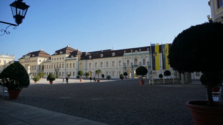 Blick auf das Schloss Ludwigsburg mit seiner beeindruckenden Architektur und gepflegten Gärten, unter blauem Himmel.