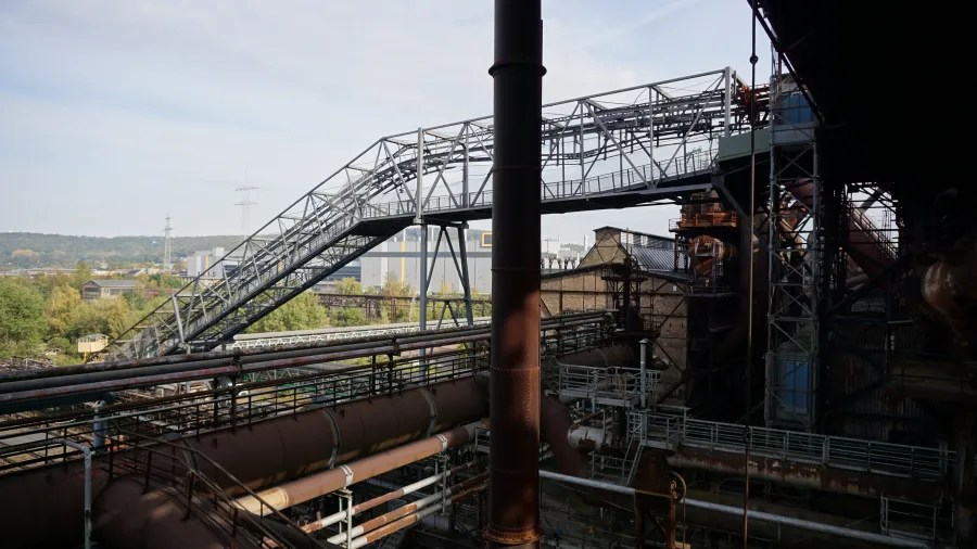 View of industrial structures and pathways at the Völklinger Hütte, showcasing the complex metal framework and machinery.