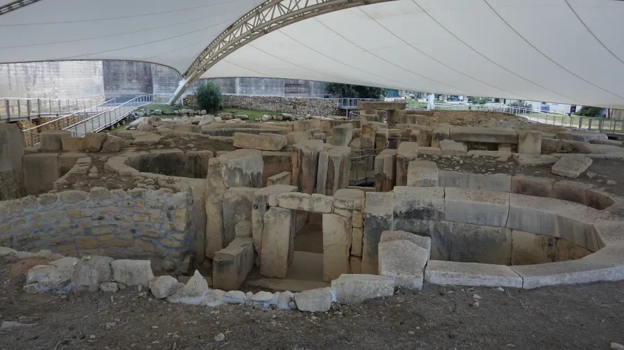 Die neolithischen Tempel von Tarxien, geschützt unter einem modernen Zelt, zeigen die Ruinen aus sandsteinfarbenen Steinen und alten Mauern, die die Jahrhunderte überdauert haben.