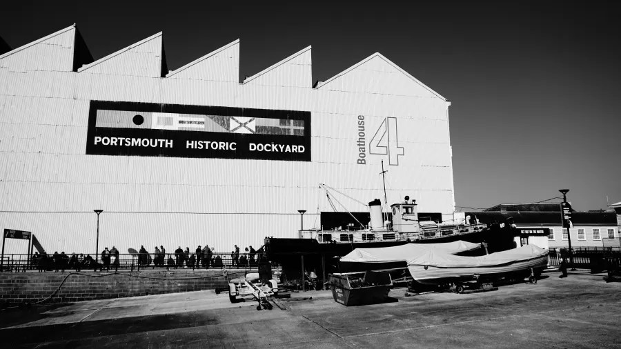 Schwarz-weiß Foto des Portsmouth Historic Dockyard mit einem Boot und dem großen Schriftzug "Boathouse 4".