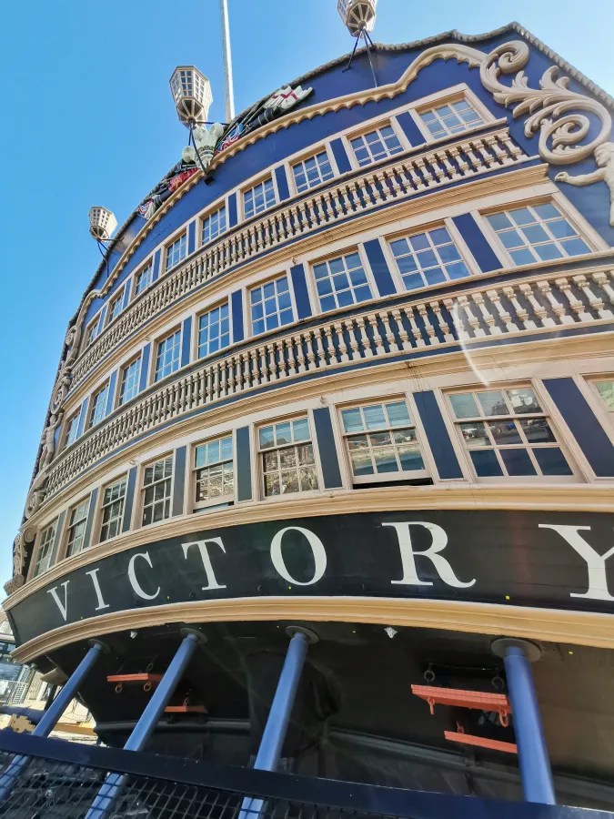 Schiffsansicht der HMS Victory mit Blick auf den Bug und das große Schild mit der Aufschrift 'VICTORY'.