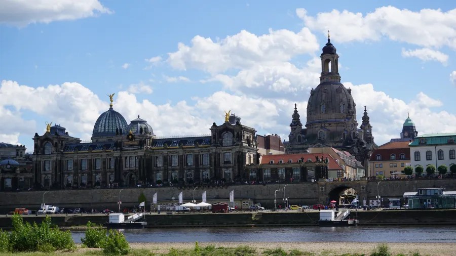 Blick auf die historische Architektur von Dresden mit der Frauenkirche und dem Zwinger, unter einem blauen Himmel mit Wolken.