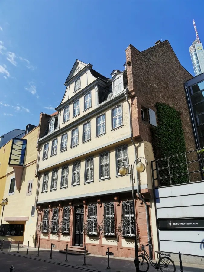 Historisches Gebäude mit Fachwerk-Fassade in der Stadt, neben moderner Architektur.