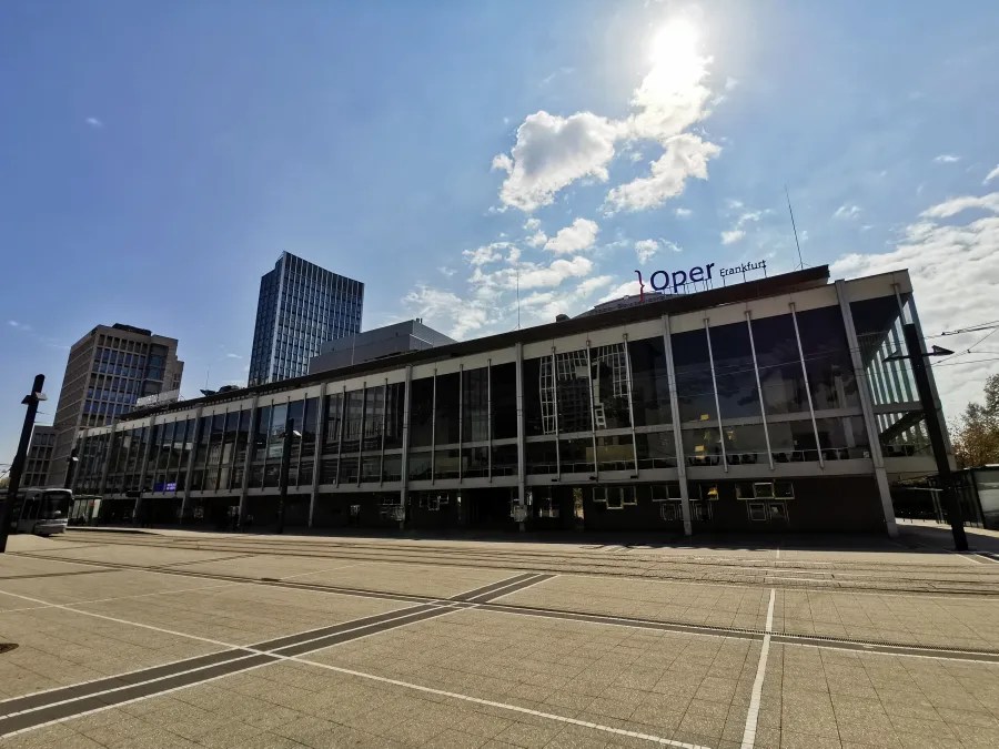 Das Opernhaus Frankfurt an einem sonnigen Tag, umgeben von moderner Architektur.