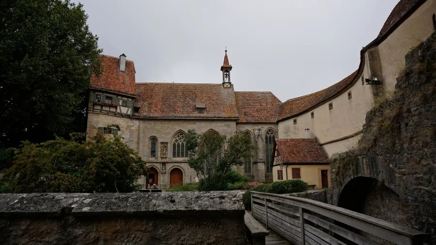 Blick auf ein historisches Gebäude mit einem spitzen Turm und Prüfen von Natur umgeben, unter einem grauen Himmel.