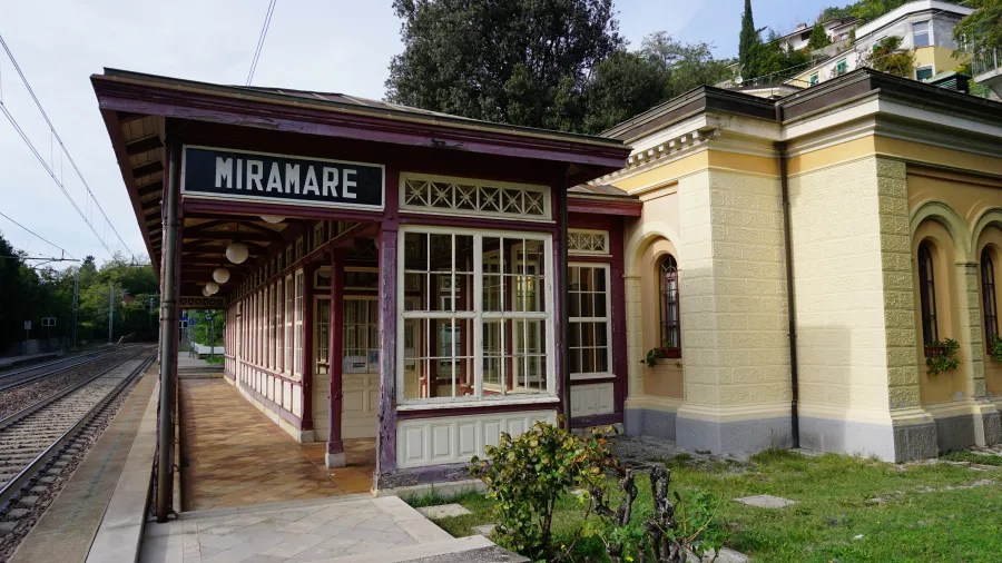 Bahnhof Miramare mit historischer Architektur und Gartenanlage.