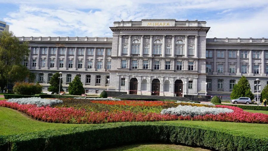 Die Mimara-Galerie in Zagreb mit einem bunten Blumenbeet im Vordergrund und einem klaren Himmel.