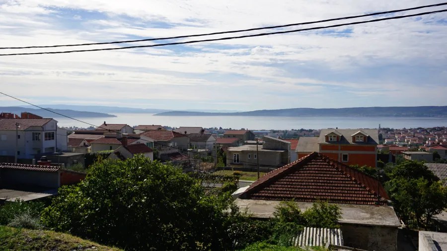 Scenic view of a coastal town with red-roofed houses overlooking a large bay