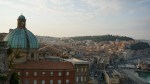 Cityscape of Ancona, Italy, featuring a prominent green dome and the harbor.