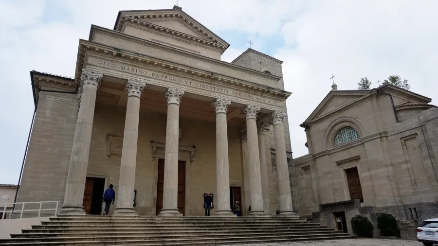 Neoclassical facade of the Basilica di San Marino with the inscription DIVO . MARINO . PATRONO . ET . LIBERTATIS . AVCTORI . SEN . P . Q