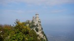 Medieval stone fortress perched on a steep rocky cliff under a clear sky