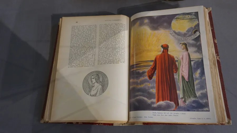 Open copy of the Divina Commedia showing an illustration of Dante and Beatrice in Paradiso.
