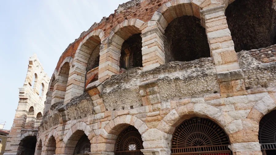 Ancient Roman amphitheater with stone arches and weathered brickwork