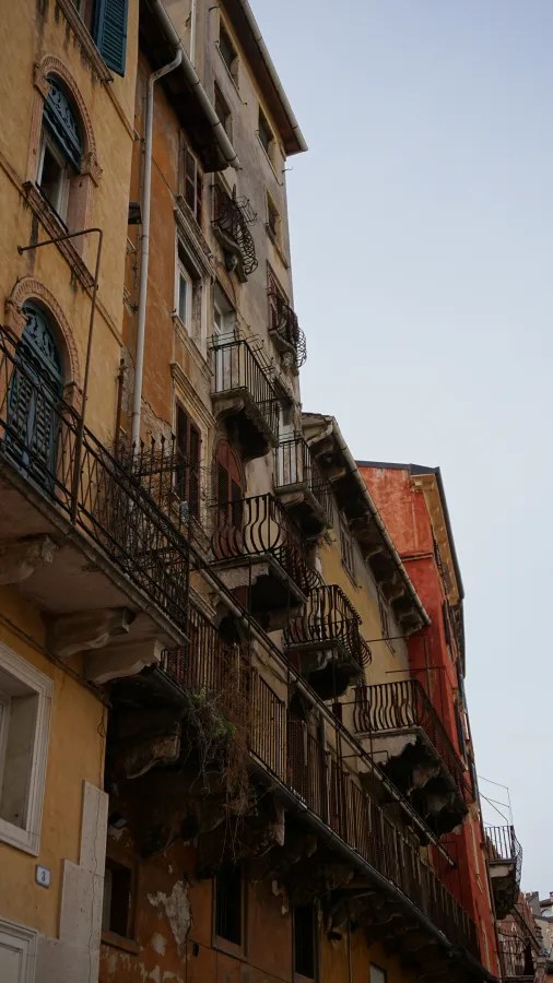 Tall, historic buildings with numerous wrought-iron balconies and arched windows.