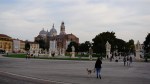 People walking in Prato della Valle square with the Abbey of Santa Giustina in the background.