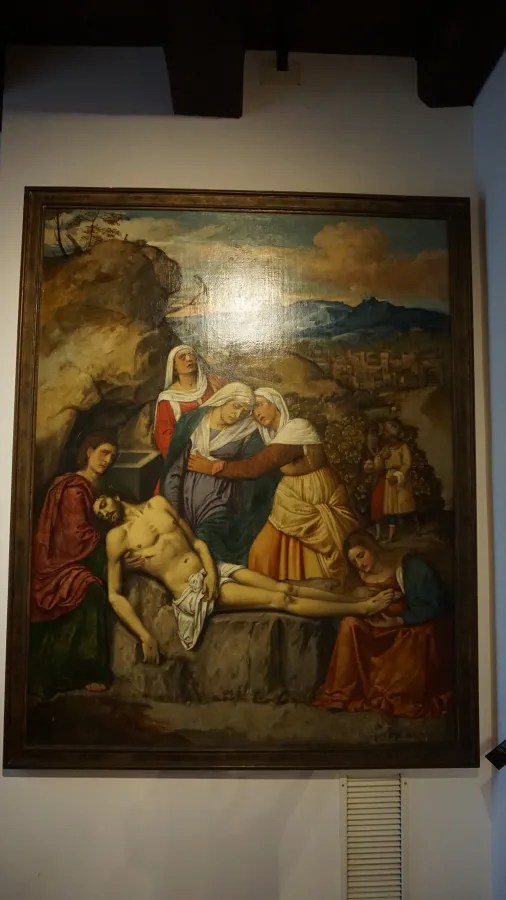Classical oil painting of the Lamentation of Christ with mourners gathered around his body.