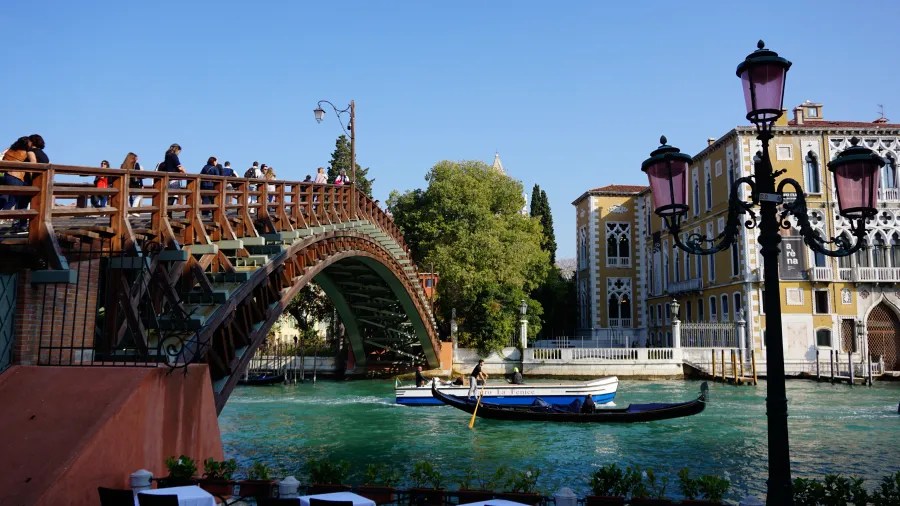 Accademia Bridge in Venice over the Grand Canal with a gondola and water taxi below